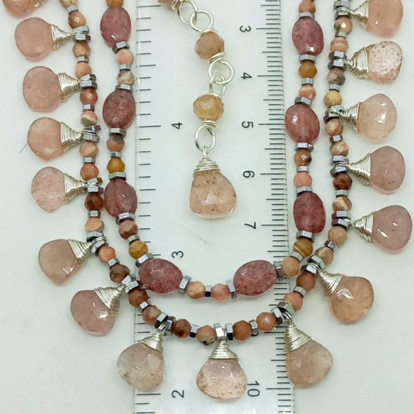 Hindistan el kesimi faset kesimli damla çilek kuvars taşlar; altı ve üç milim ebatlı faset kesim rondela çilek kuvars, Hematit taşlar birlikte çalışılarak, çelik aparat ve gümüş kaplama materyaller ile 43 cm uzunluğunda tasarlanmış EL YAPIMI kolye.